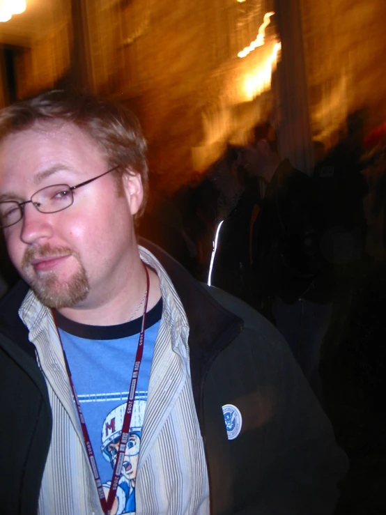 a man with glasses and a badge on his neck