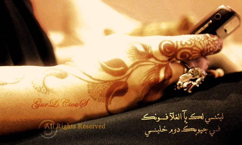 hand with tattoo and cellphone displaying arabic script