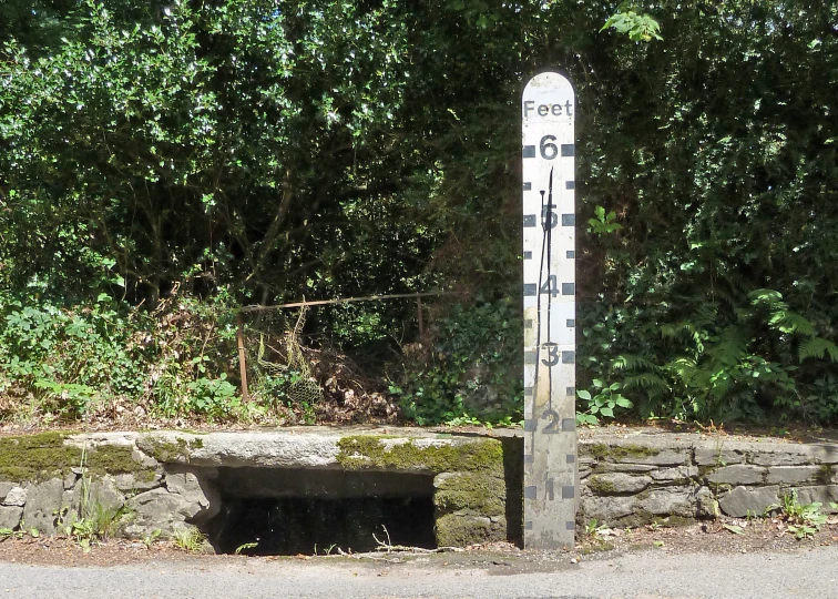 a pole with a measuring tape and bench on it