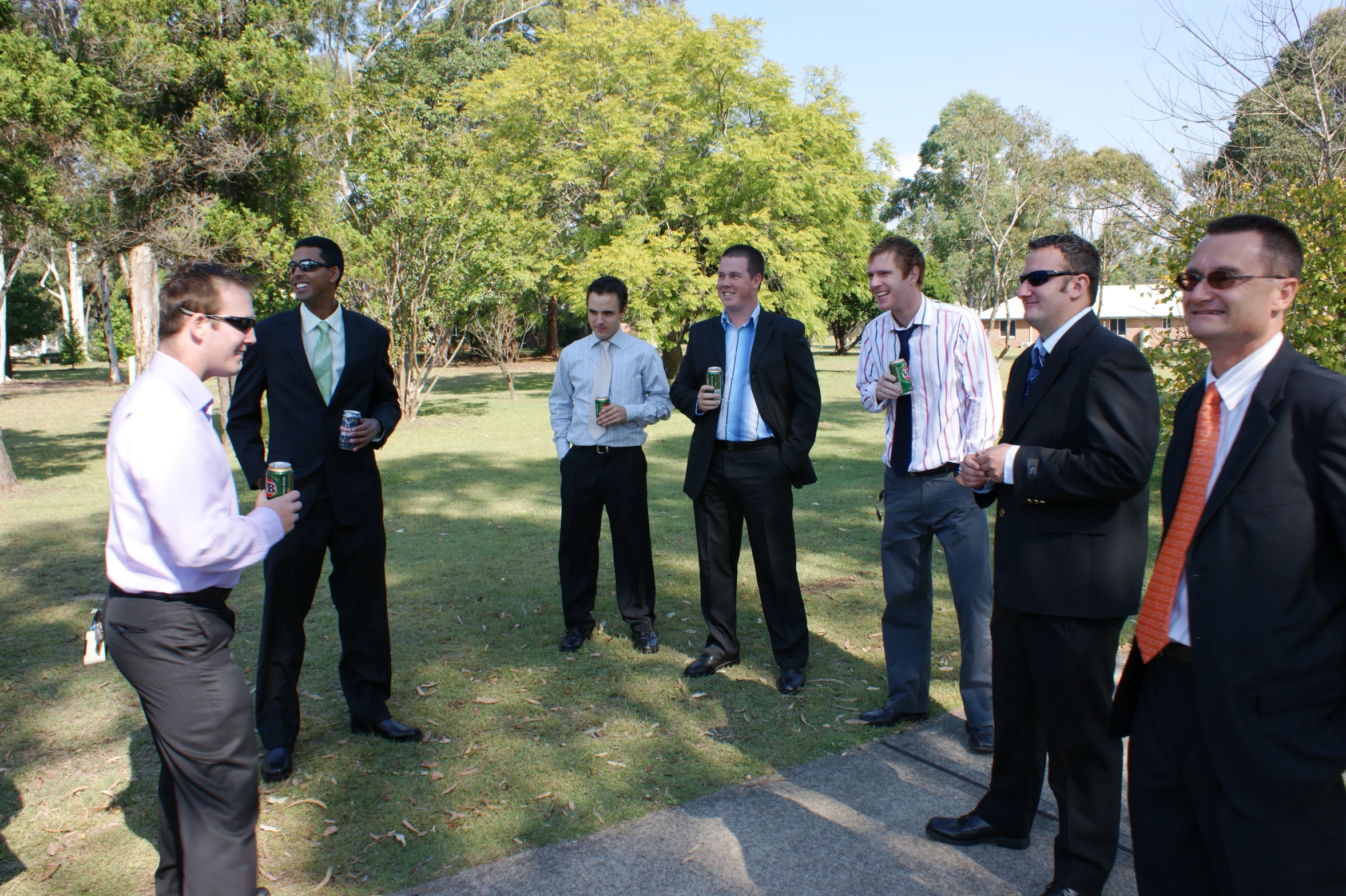 men in suits are standing around outside talking