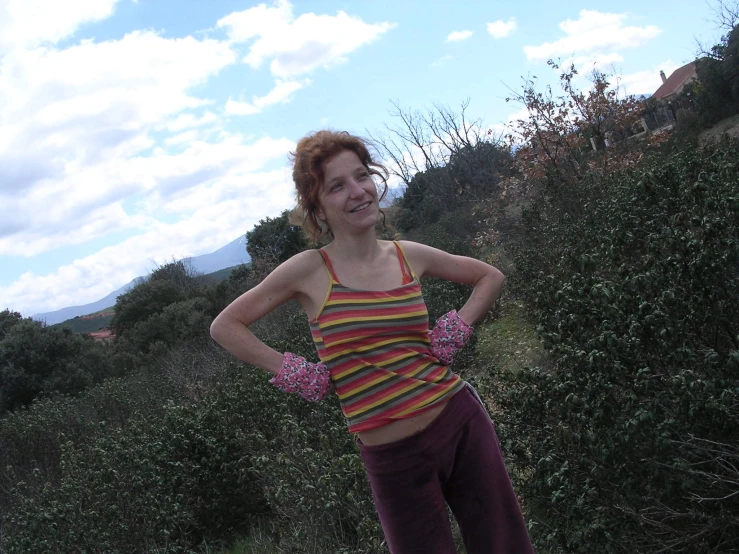 a young woman posing outside with her hands on her hips