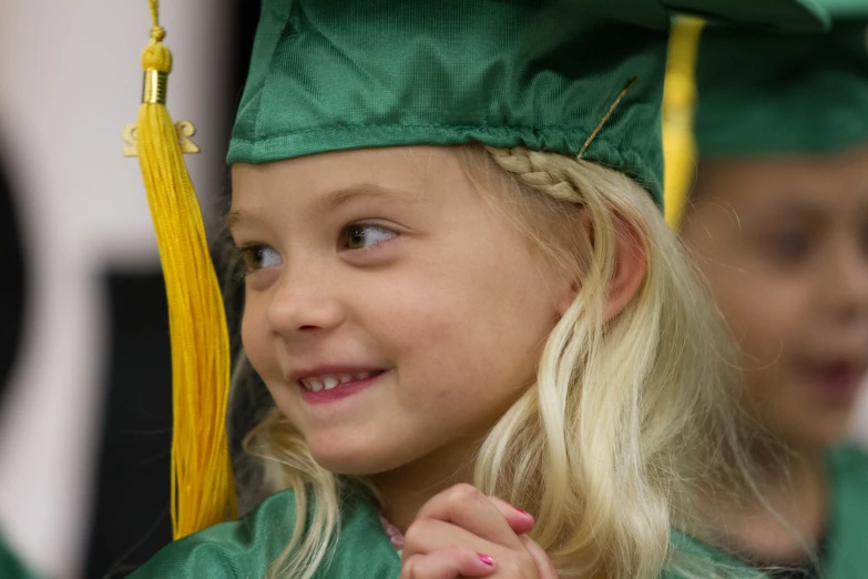 young female student in a graduation gown with her friend