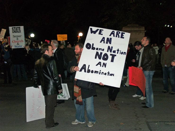 people are gathered together, holding protest signs