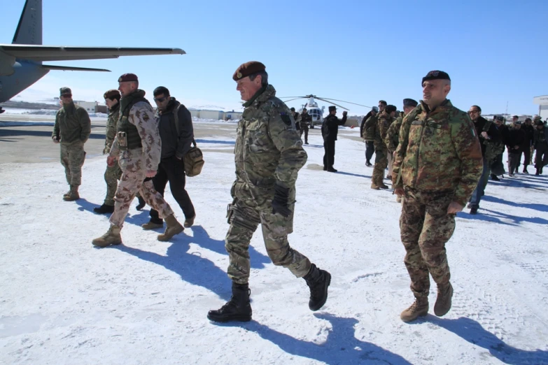 several soldiers are walking on a snowy surface