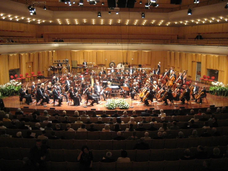 orchestra on stage during performance with lights on