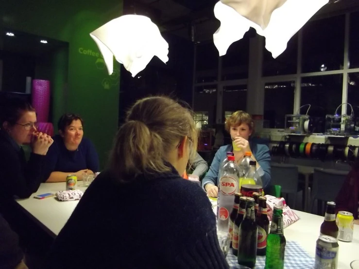 four people sit around a long table in a dark room