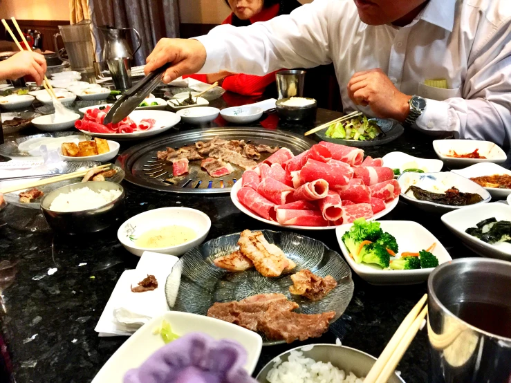 man preparing food on a tray at a table with bowls of soup