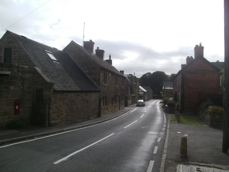 a street lined with older brick buildings and some cars parked in front of them