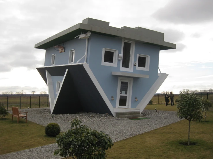 a very unusual building sitting in a grassy field