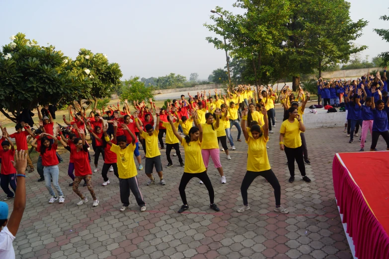 a large group of people dance around on the sidewalk