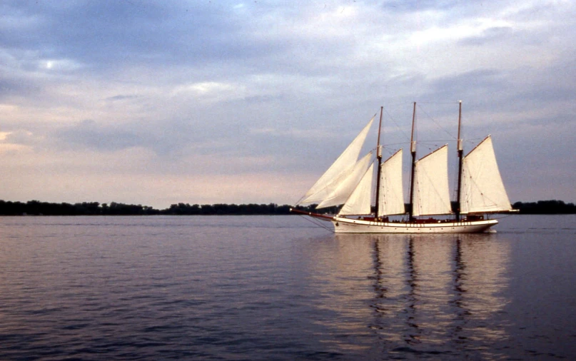 a boat is sailing on the water on a cloudy day