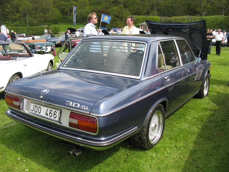 the car is parked at an event with many other cars