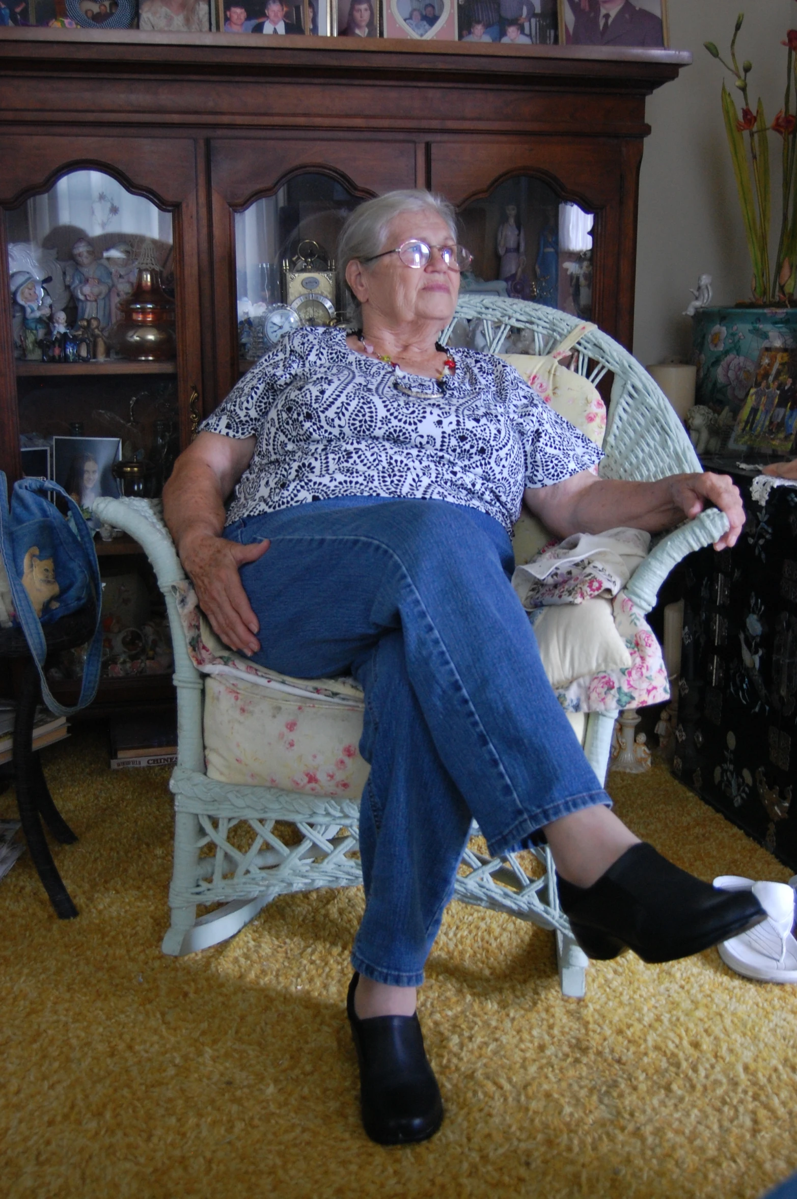 an elderly woman sitting on top of a white chair