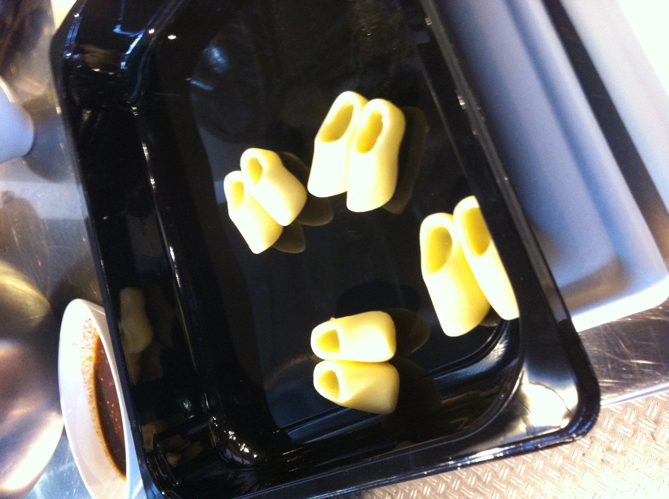 pasta is being made in a black dish