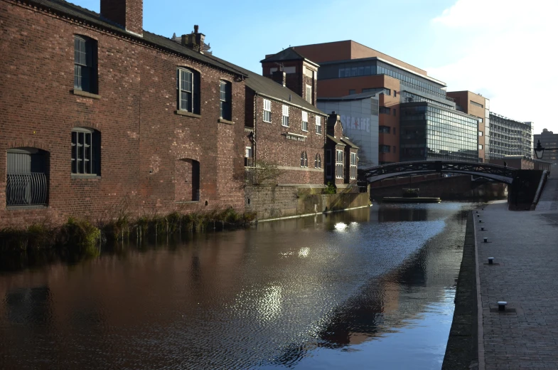 a brick building with windows and a bridge in the background