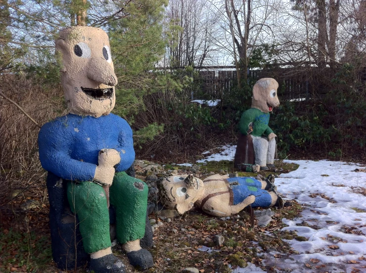 two statues of people with faces painted like humans