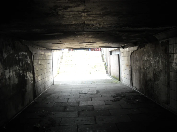 a dark passage in a concrete tunnel filled with bricks