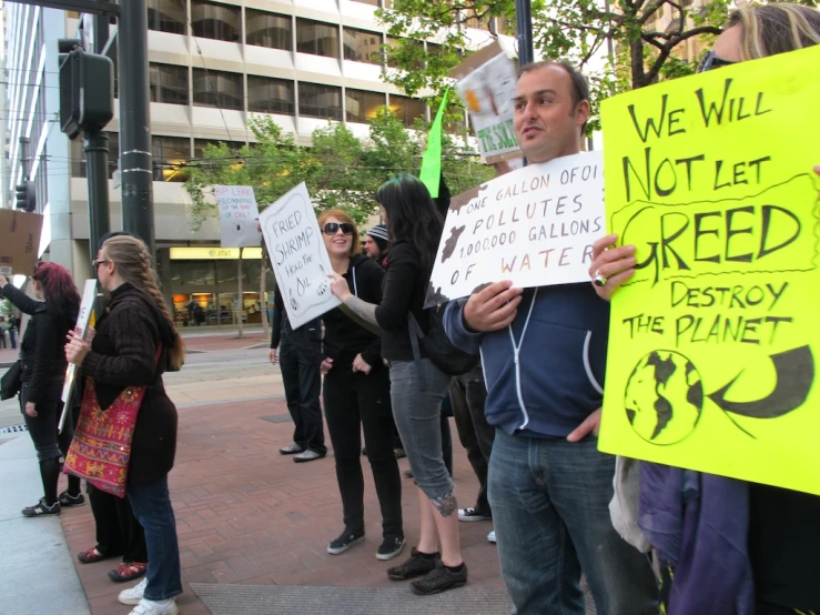 a group of people standing around each other holding signs