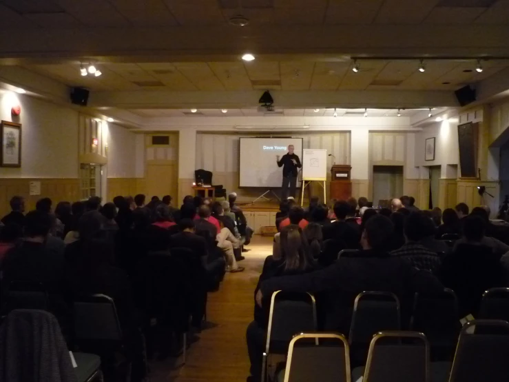 a man is giving a speech in a large room