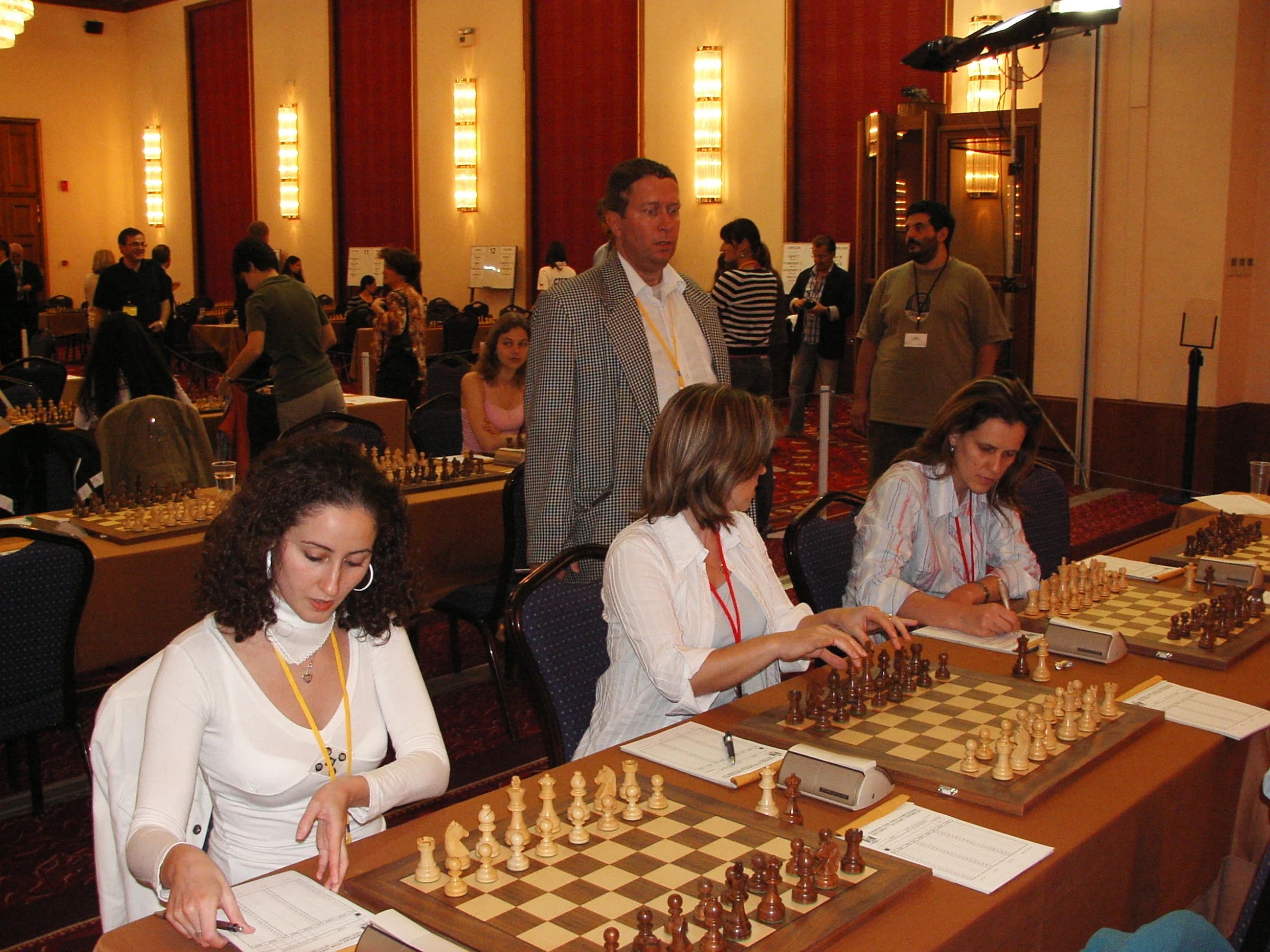 group of people gathered at table playing chess