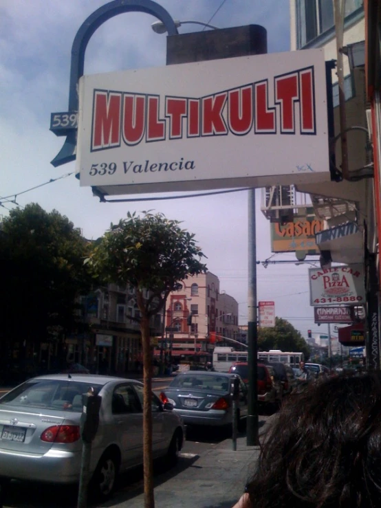 an italian business sign on a busy sidewalk in the city