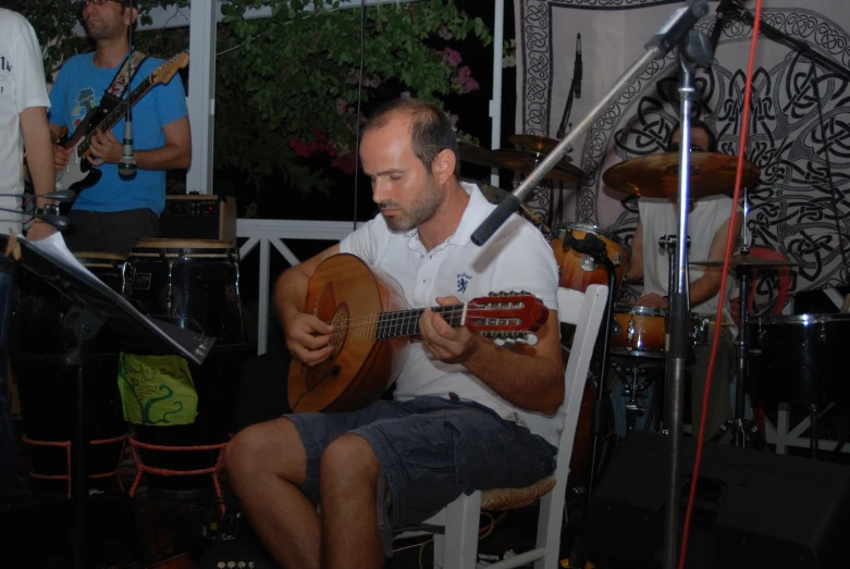 the man is playing his instrument in front of the microphone