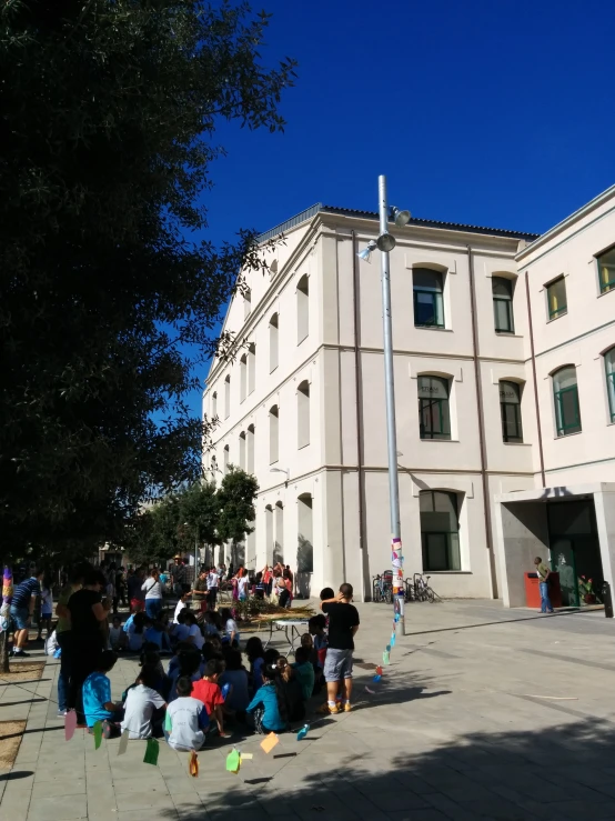 people are outside the old building with flags flying