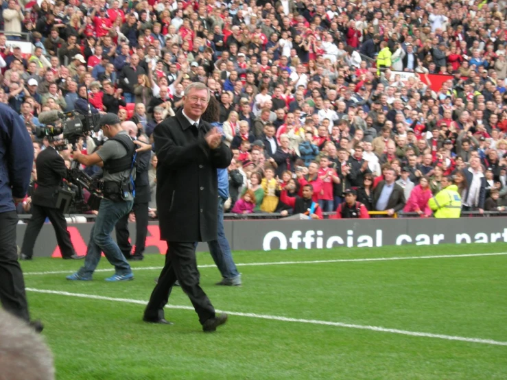 a man walking across a field at a sporting event