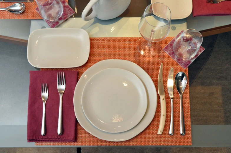 the place setting has a white plate and silverware
