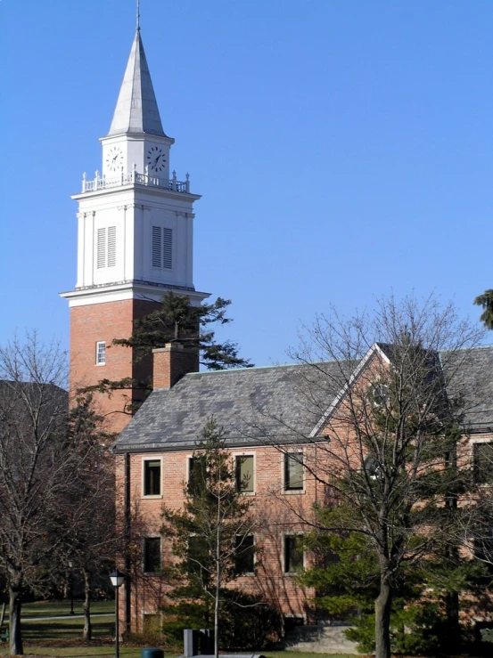 the steeple of an old brick building with a clock in the middle