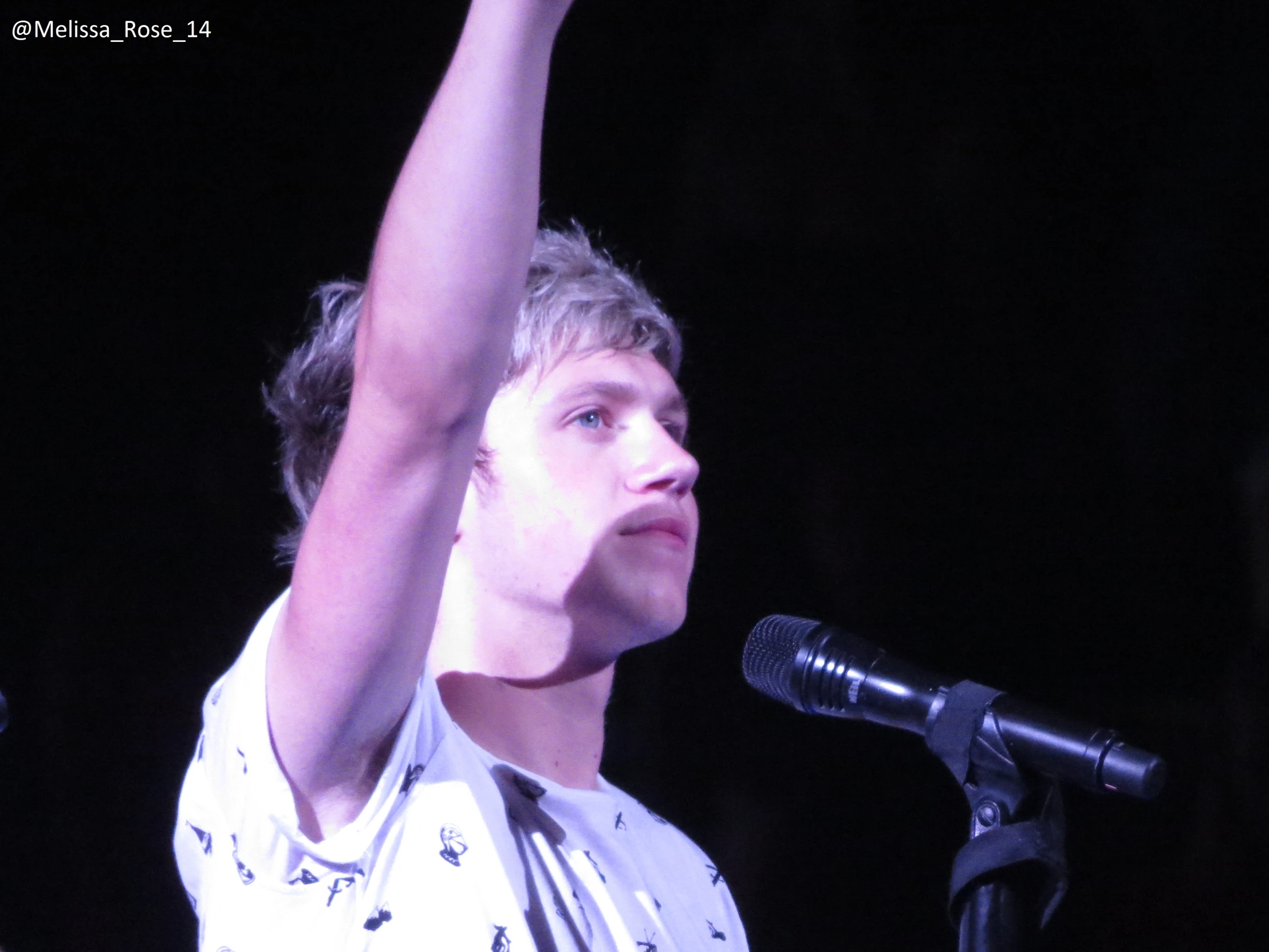 young man with hand in the air with a microphone and an arm raised