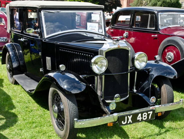 several classic cars are on display in an open field