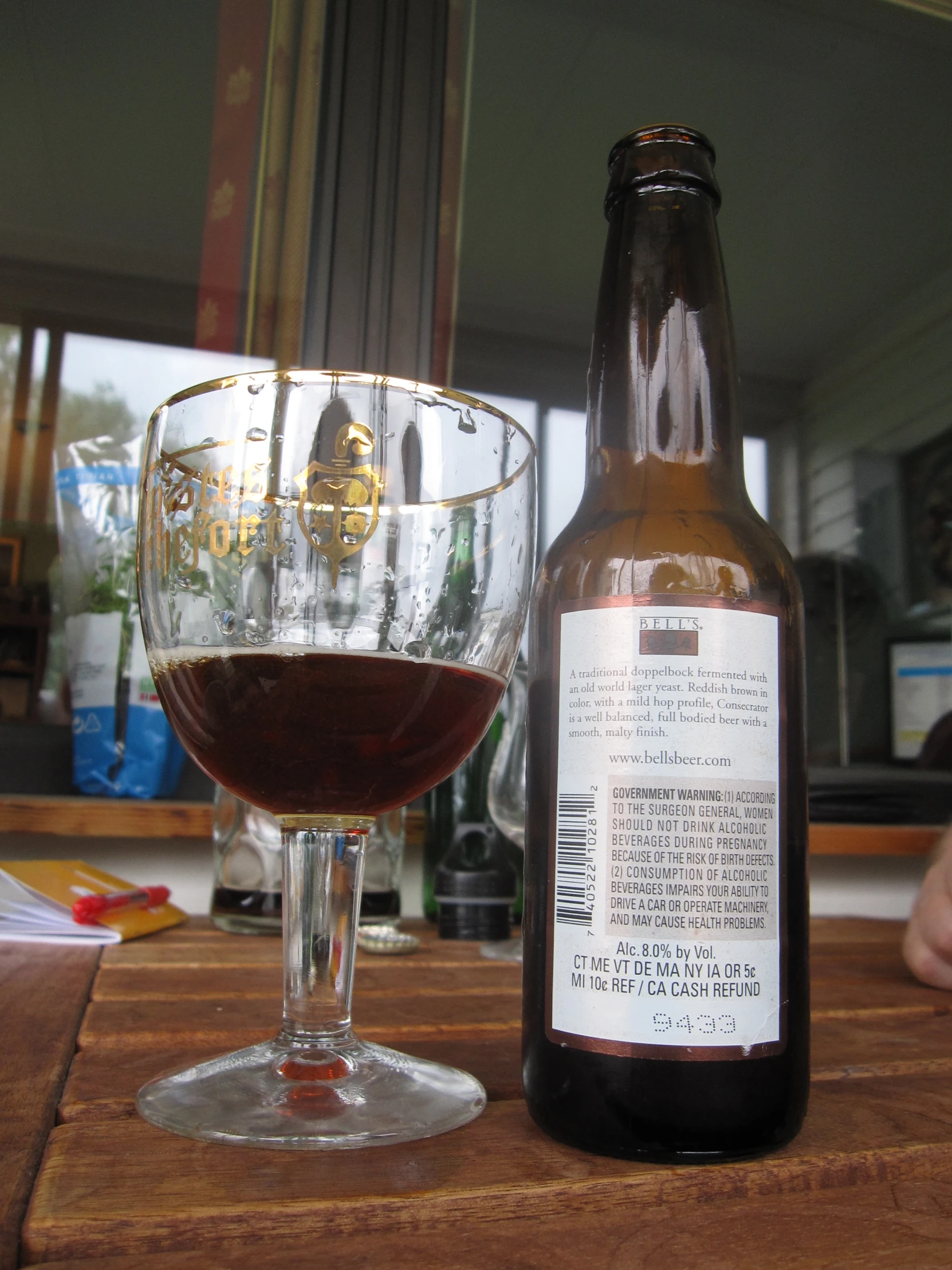 a bottle and a glass sit on a table