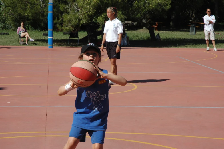 a young man is practicing throwing a basketball to the crowd