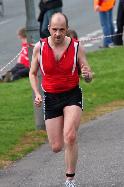 the man is running on the street with many people behind him