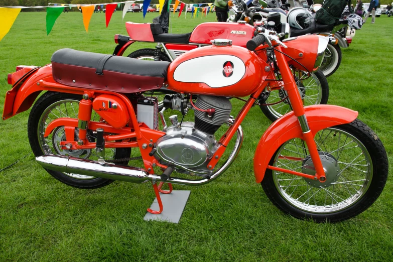 a red motor bike parked on a lush green field