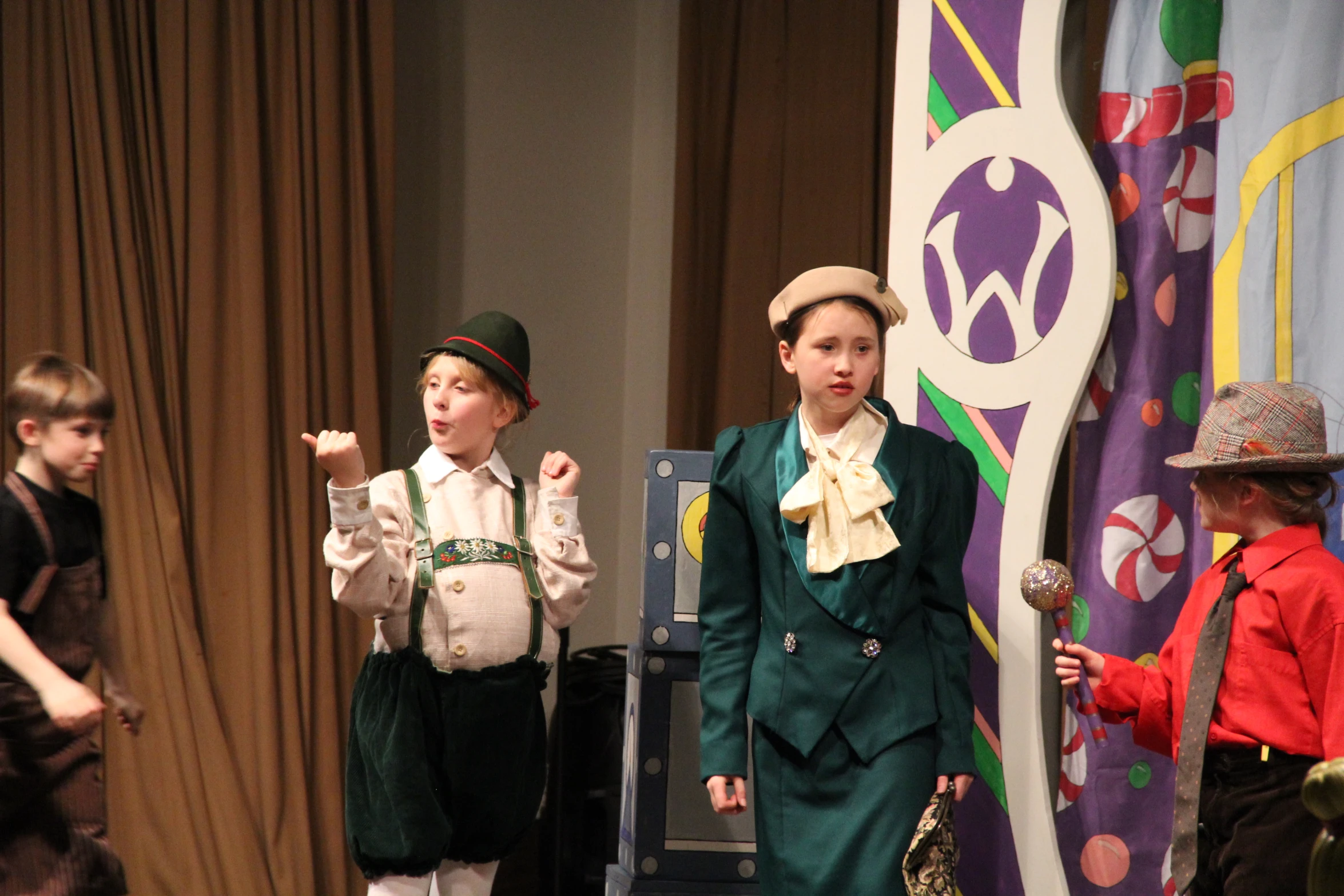 a group of s standing on a stage with one in costume