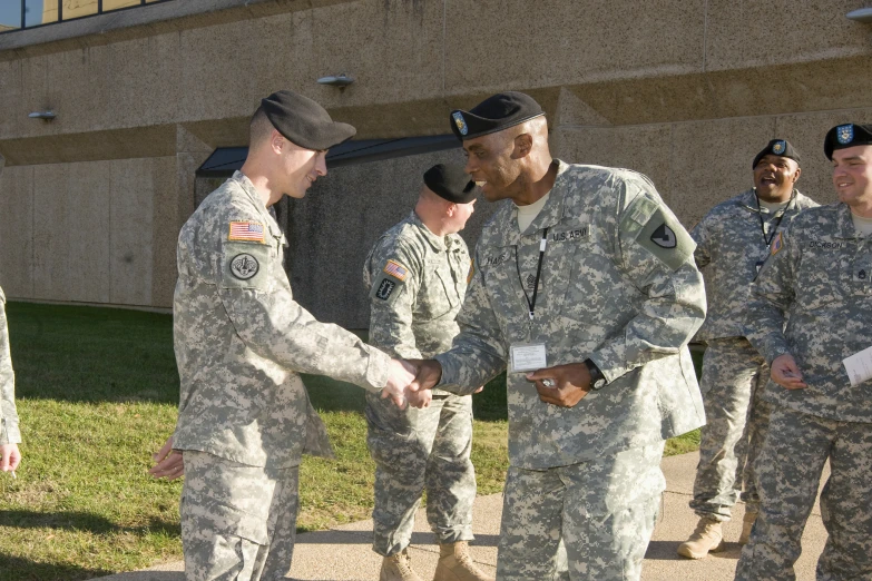 two soldiers are shaking hands with another man