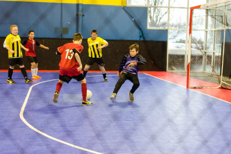 children playing soccer inside a large indoor indoor court