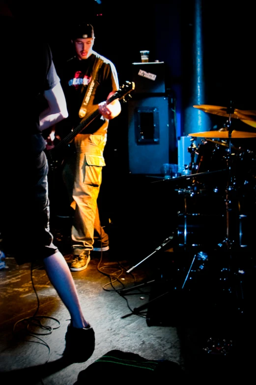 a drummer is playing on a band as a man looks on