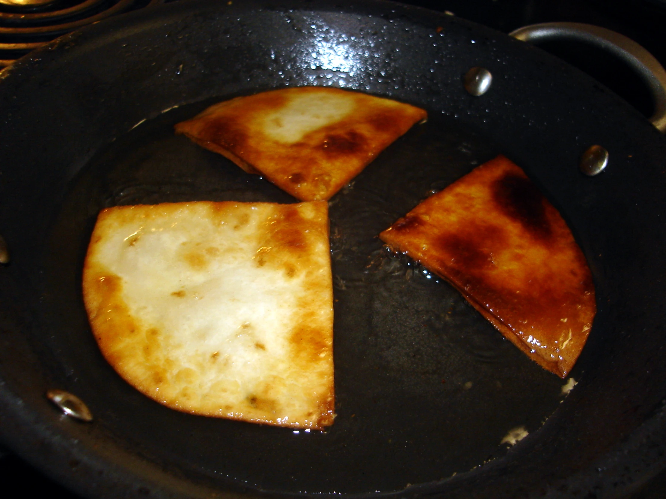 pieces of food being cooked in a pan