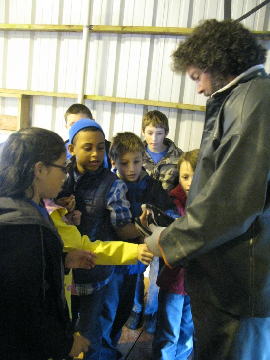 an adult stands over children who are talking