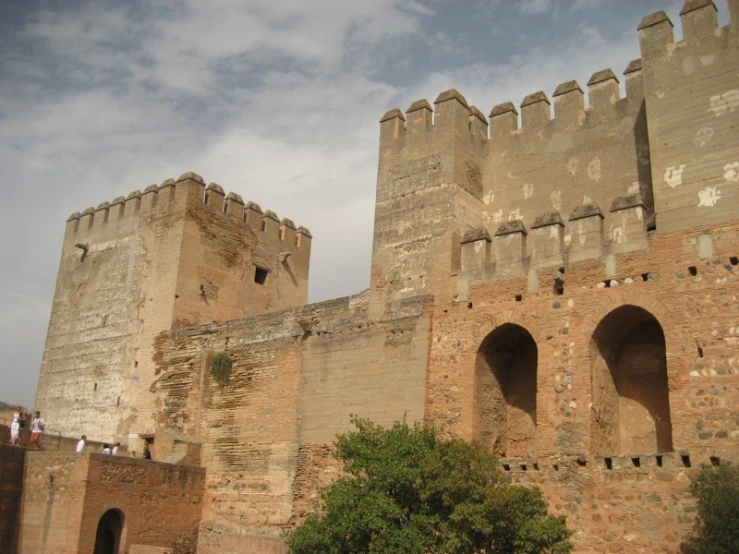 people are standing outside the medieval looking building