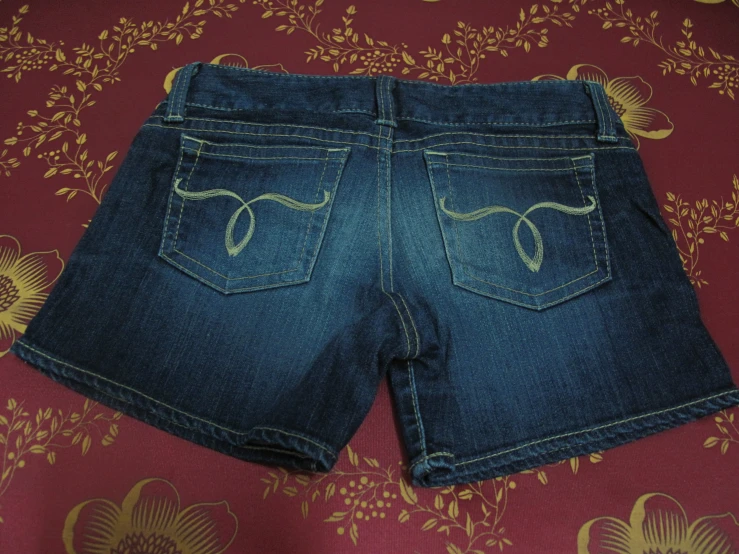 two jean jeans, one has the tail flap and other has the tail flap down