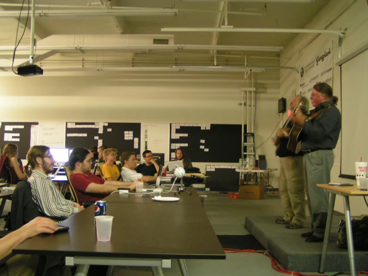 a person plays an instrument as others listen