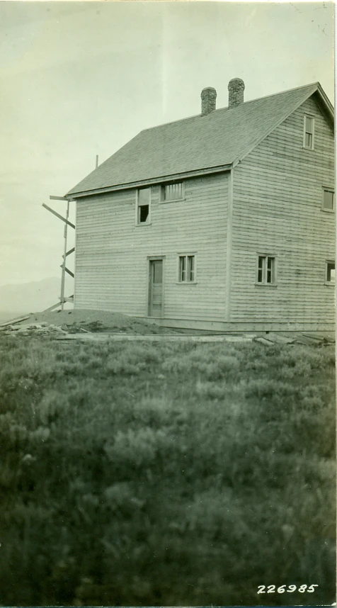 a large white barn sits atop a hill