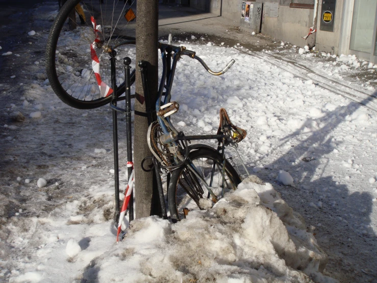 a bike leaning on a pole covered with snow