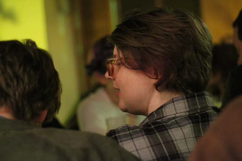 a woman with eyeglasses on in a crowded room