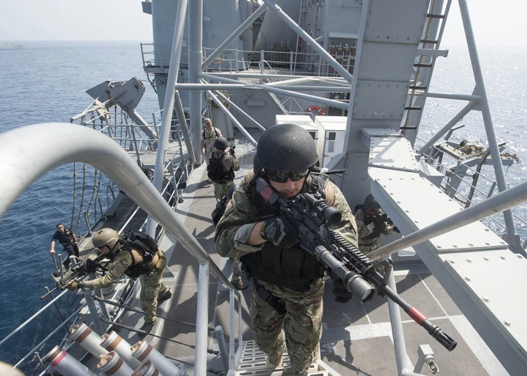 military men standing on a ship with guns