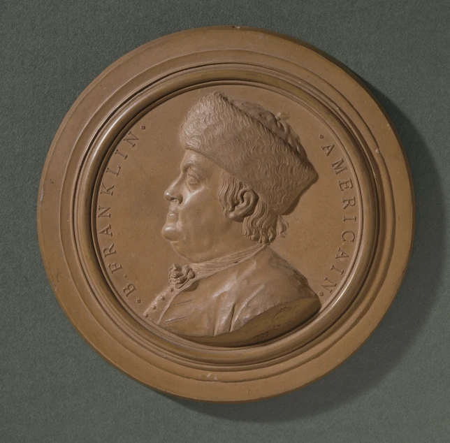 a bronze medal depicting a portrait of a man